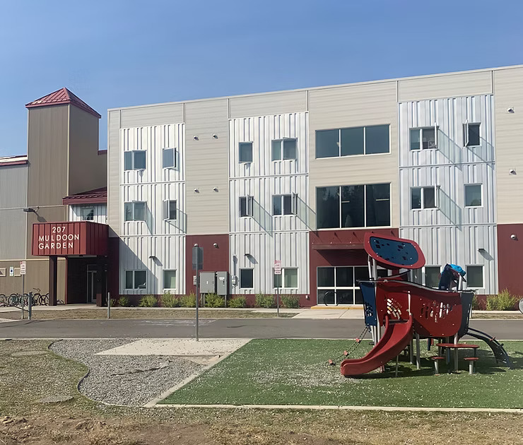 Muldoon Garden Apartments modern affordable housing building with playground
