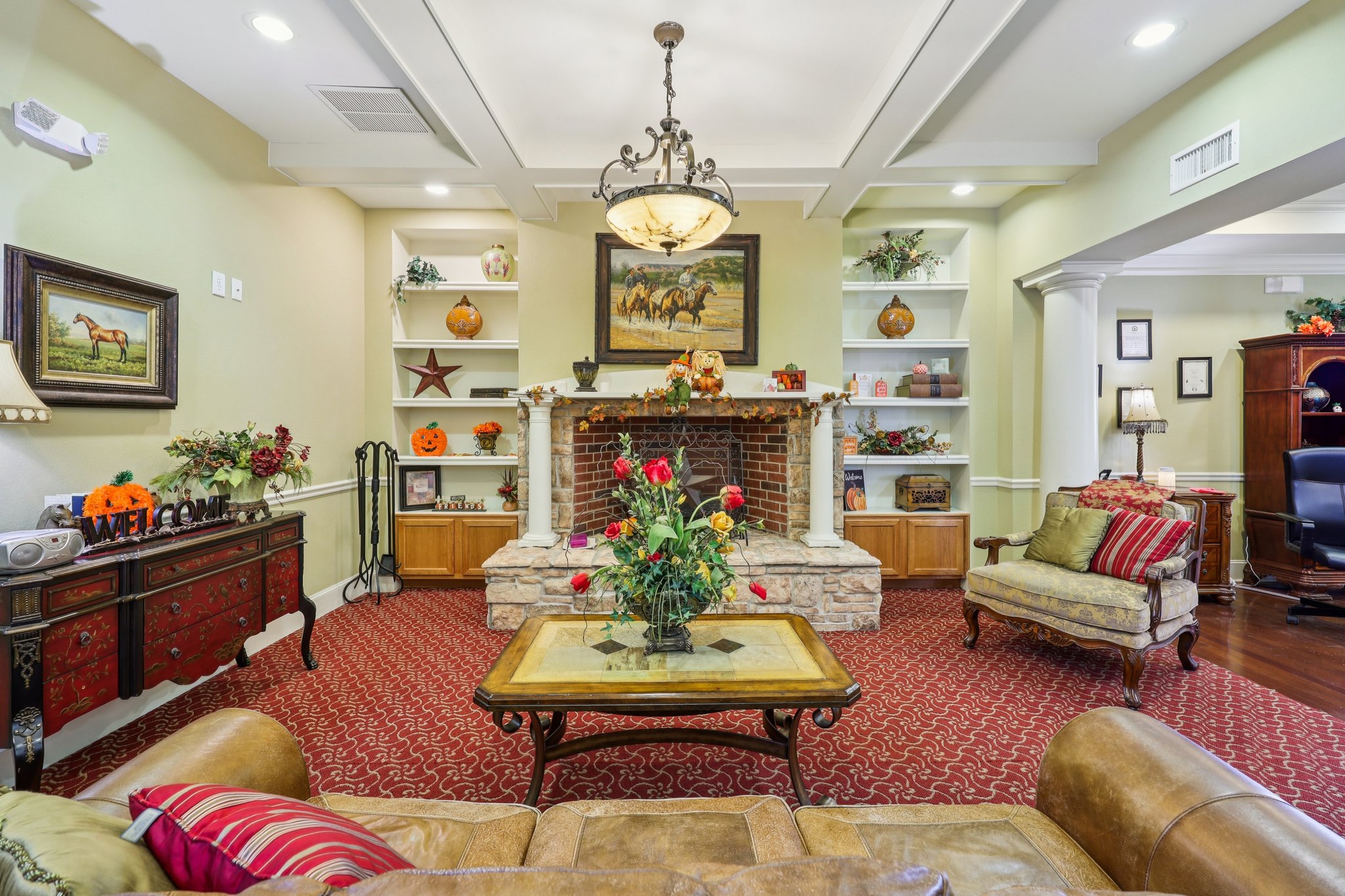 Sunset Pointe clubhouse lounge with fireplace and built-in shelves in Fort Worth, TX
